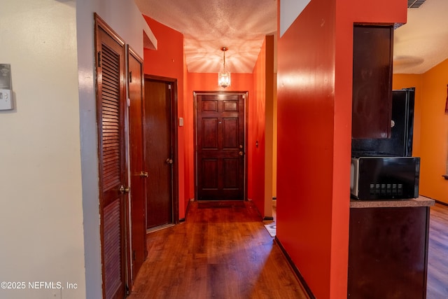 corridor featuring dark wood-style flooring