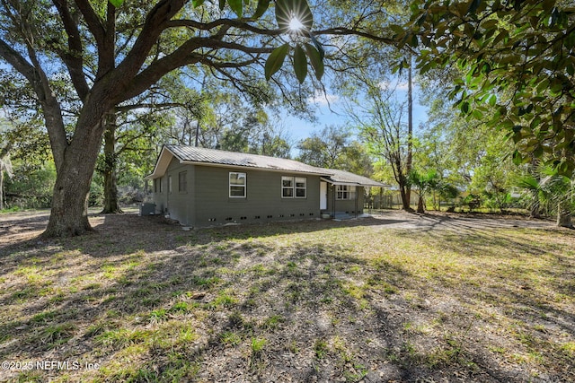 rear view of property with central air condition unit, fence, and metal roof