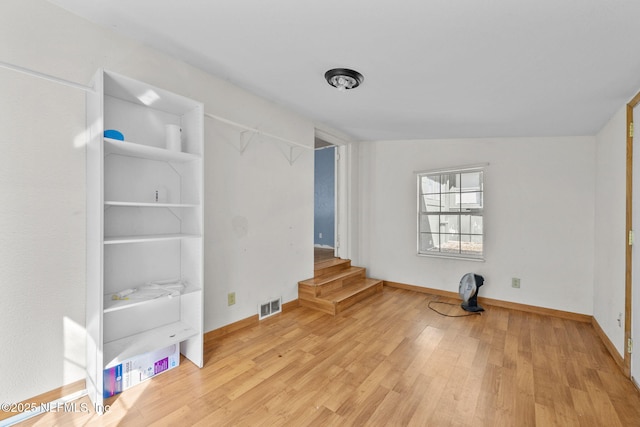 interior space featuring visible vents, baseboards, and wood finished floors