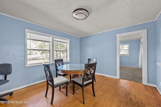 dining space featuring baseboards and wood finished floors