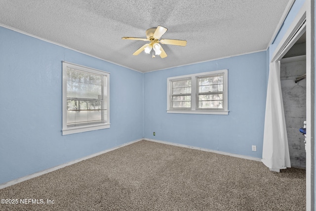 unfurnished bedroom with a textured ceiling, ceiling fan, a closet, and carpet flooring