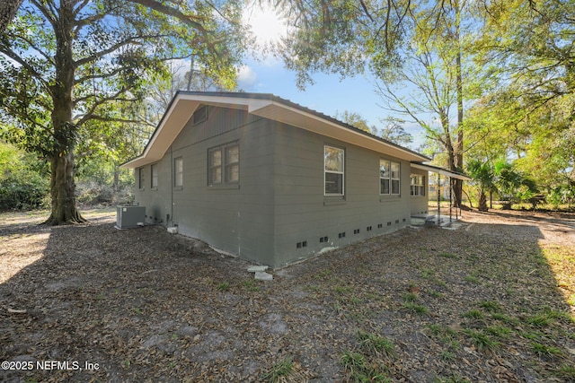 view of side of property with crawl space and central AC