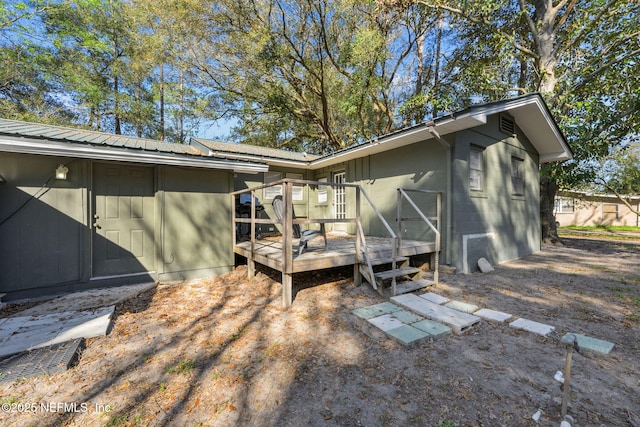 exterior space with metal roof, concrete block siding, and a deck