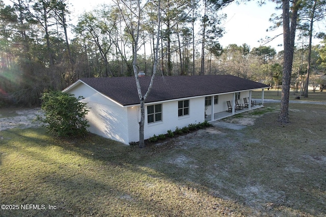 ranch-style home featuring dirt driveway, a shingled roof, and a porch