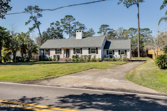 ranch-style home featuring a front yard, fence, and a chimney