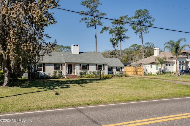 ranch-style house with a chimney, fence, and a front yard