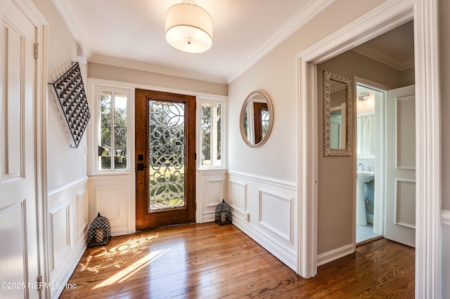 entrance foyer with a wainscoted wall, hardwood / wood-style floors, and crown molding