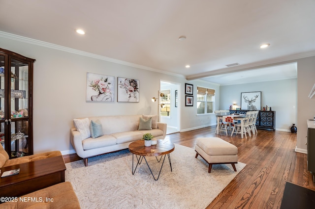 living room featuring dark wood-style flooring, crown molding, and baseboards