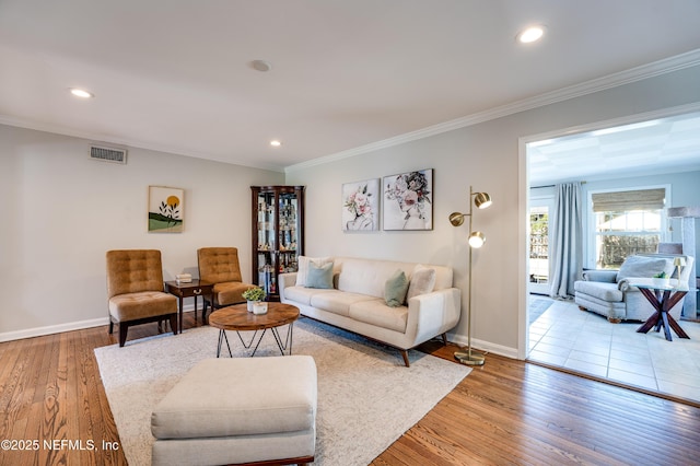 living room with baseboards, visible vents, ornamental molding, wood finished floors, and recessed lighting