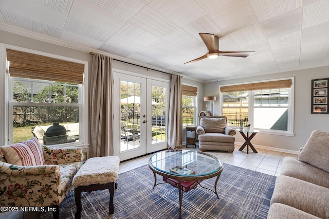 tiled living area featuring ceiling fan, french doors, and baseboards