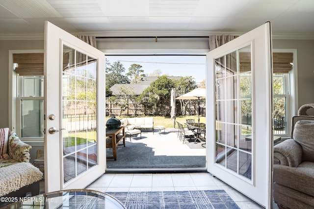 doorway to outside featuring crown molding and tile patterned floors