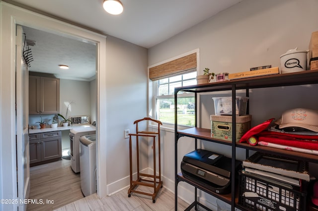 interior space with baseboards, laundry area, washing machine and dryer, and light wood-style floors