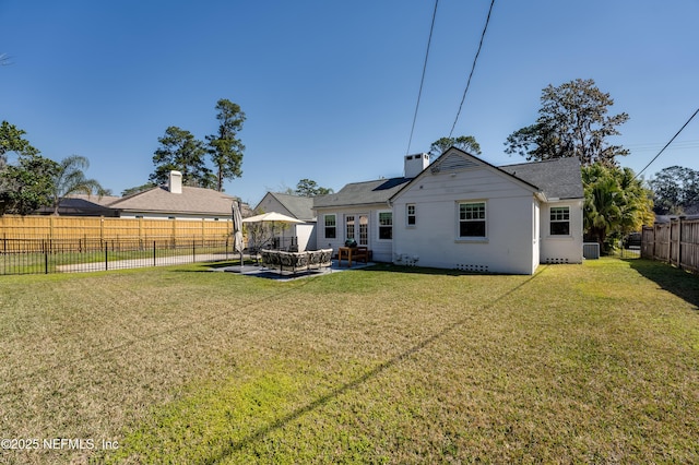 back of property featuring a fenced backyard, central AC, a patio, and a yard