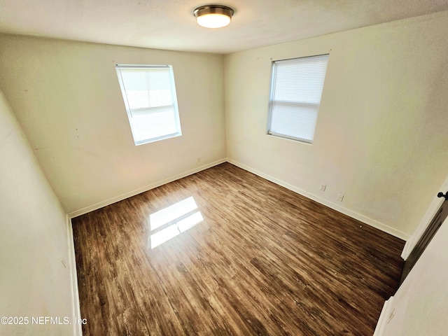 unfurnished room featuring wood finished floors and baseboards