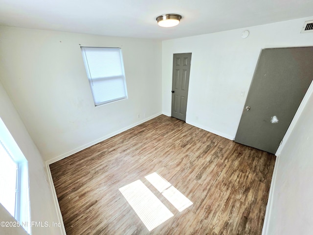 unfurnished bedroom featuring wood finished floors and baseboards