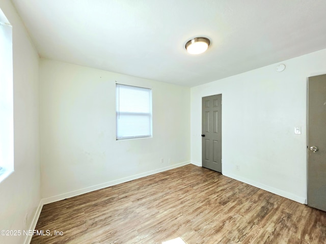 empty room featuring wood finished floors and baseboards