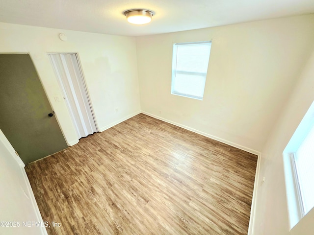 spare room featuring wood finished floors and baseboards