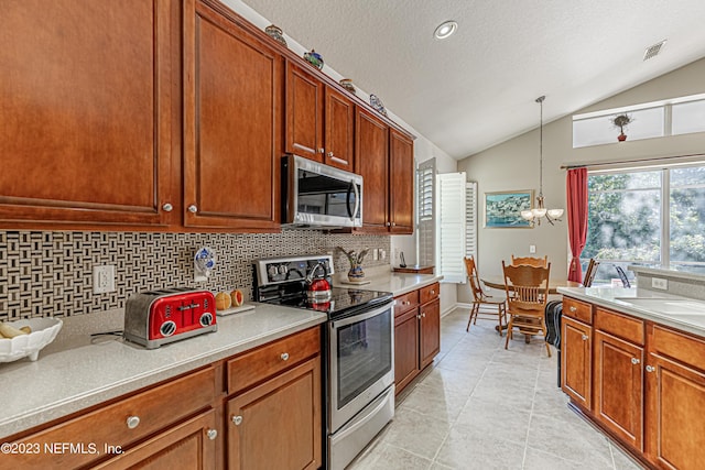 kitchen with decorative backsplash, vaulted ceiling, light countertops, and appliances with stainless steel finishes