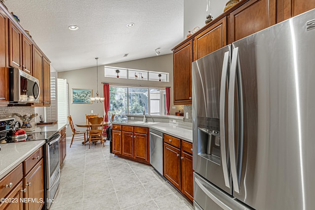 kitchen featuring tasteful backsplash, light countertops, lofted ceiling, light tile patterned flooring, and stainless steel appliances