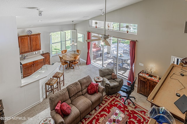 living area featuring light tile patterned floors, visible vents, baseboards, and a textured ceiling