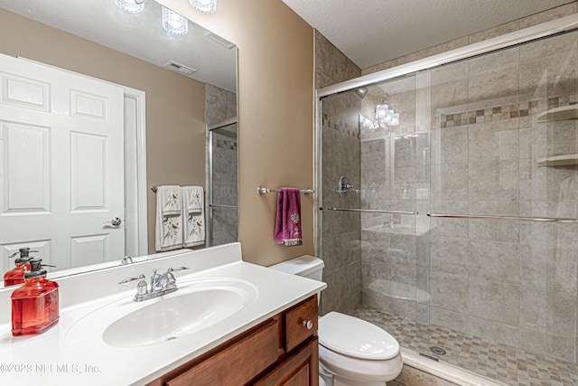 bathroom with visible vents, toilet, a stall shower, and vanity