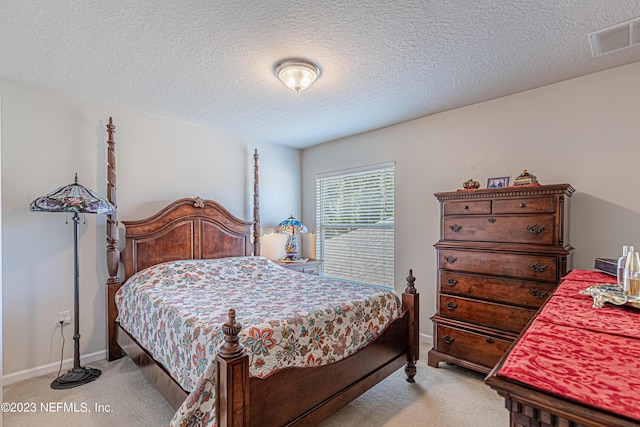 bedroom featuring visible vents, light colored carpet, a textured ceiling, and baseboards