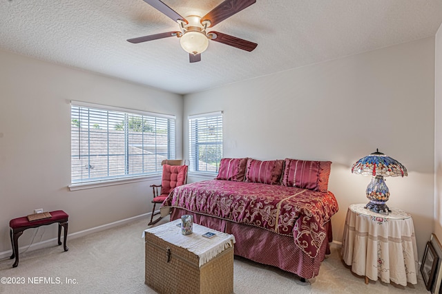 bedroom with a ceiling fan, baseboards, carpet floors, and a textured ceiling