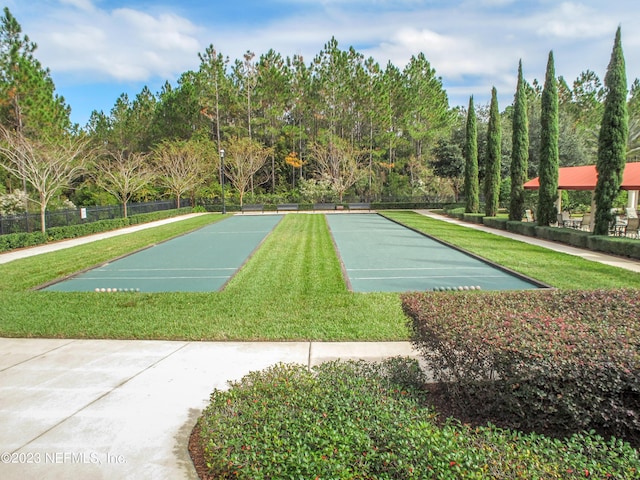 view of property's community with a yard and fence