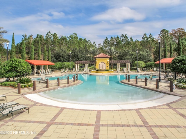 community pool with a patio and a pergola