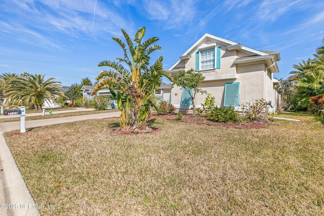 view of front facade with a front lawn and stucco siding