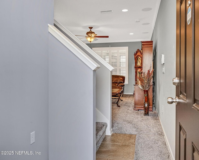 foyer with visible vents, ceiling fan, stairway, ornamental molding, and carpet floors