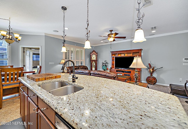 kitchen featuring ornamental molding, open floor plan, and a sink