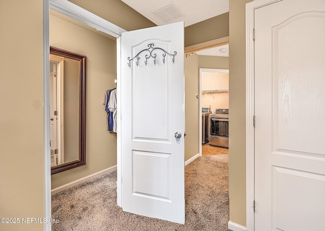 hallway with carpet floors, baseboards, and visible vents