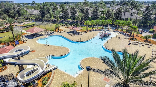 view of swimming pool with a water slide and fence