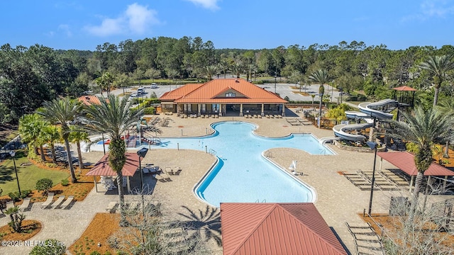 community pool featuring a water slide and a patio area