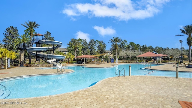 pool featuring a water slide, a patio area, fence, and a gazebo