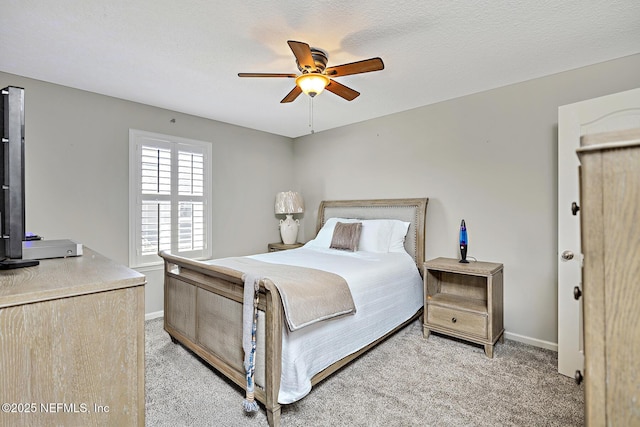 bedroom featuring light colored carpet, ceiling fan, a textured ceiling, and baseboards