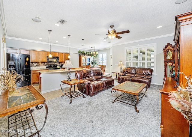 living area with a ceiling fan, visible vents, crown molding, and a textured ceiling