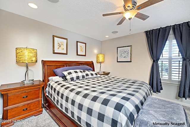 bedroom featuring carpet, ceiling fan, and a textured ceiling