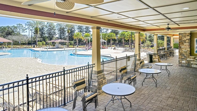 pool with ceiling fan, fence, and a patio