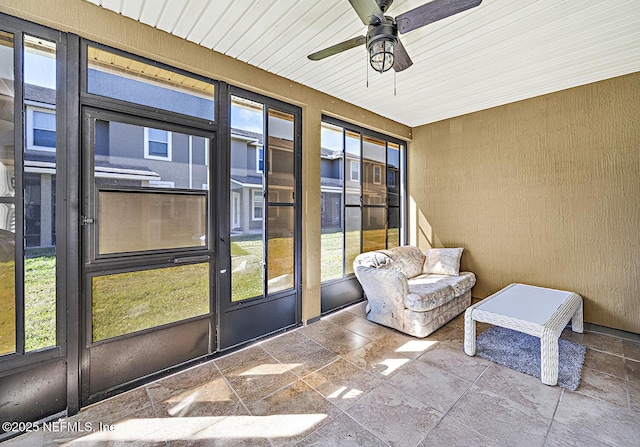 unfurnished sunroom with ceiling fan and plenty of natural light