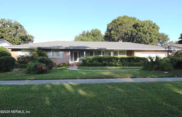 single story home with a front lawn, brick siding, and an attached garage