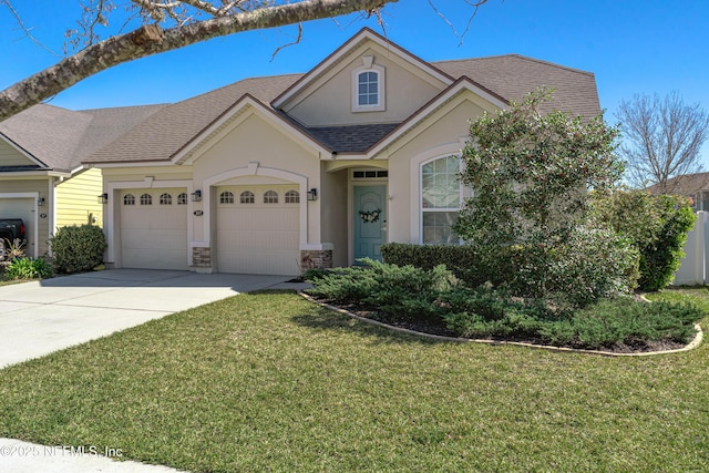 view of front of home with driveway, a garage, roof with shingles, a front yard, and stucco siding