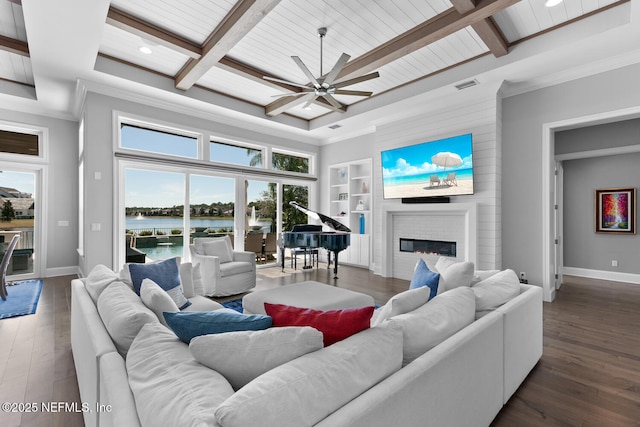 living room featuring plenty of natural light, visible vents, hardwood / wood-style floors, and a glass covered fireplace