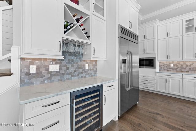 kitchen featuring ornamental molding, glass insert cabinets, white cabinetry, built in appliances, and beverage cooler