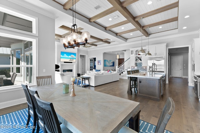 dining space with a fireplace, beam ceiling, coffered ceiling, and dark wood-type flooring