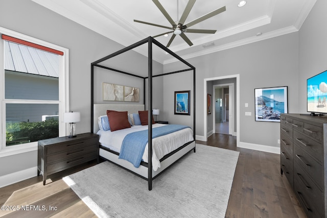 bedroom with baseboards, visible vents, a raised ceiling, dark wood-style floors, and ornamental molding