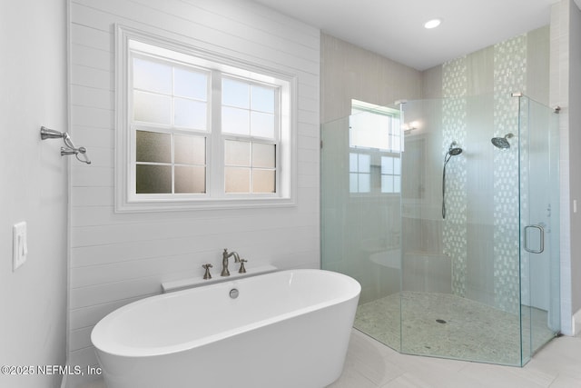 full bathroom featuring a freestanding bath, a stall shower, and tile patterned flooring