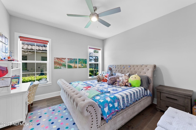 bedroom with a ceiling fan, baseboards, and dark wood-type flooring