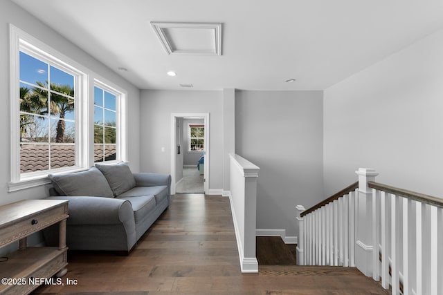 living area with recessed lighting, attic access, an upstairs landing, wood finished floors, and baseboards